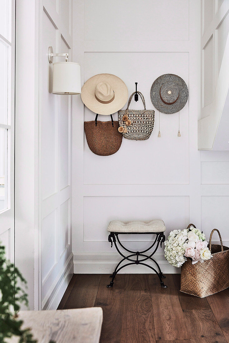 Hats and bags on the coat rack in the hallway with coffered walls
