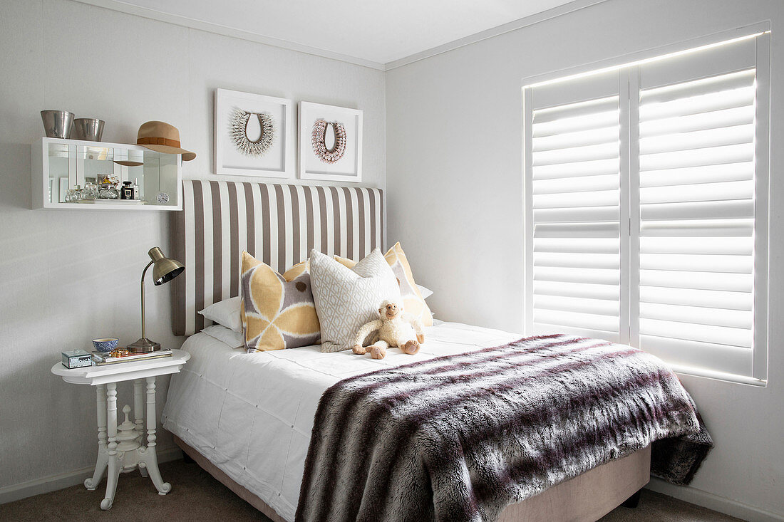 Bed with striped headboard in classic child's bedroom