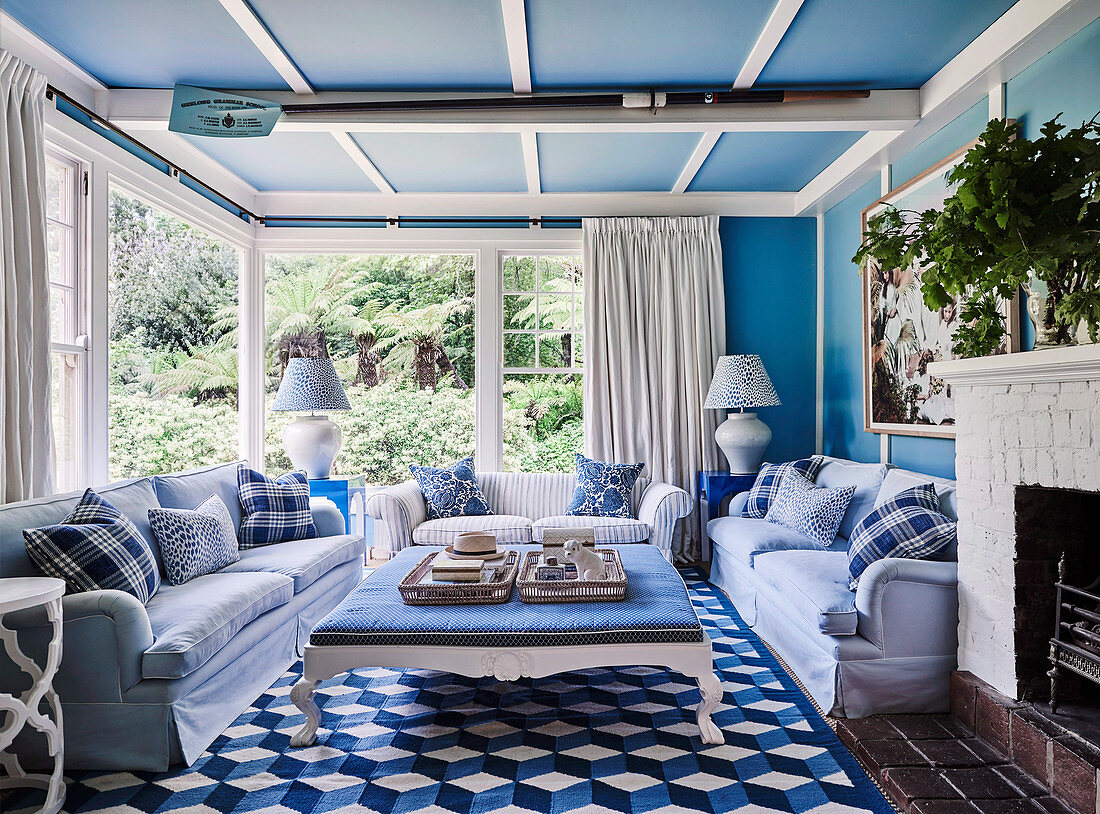 Wohnzimmer in Blau-Weiß mit Sofa-Sitzgruppe um nostalgischen Couchtisch