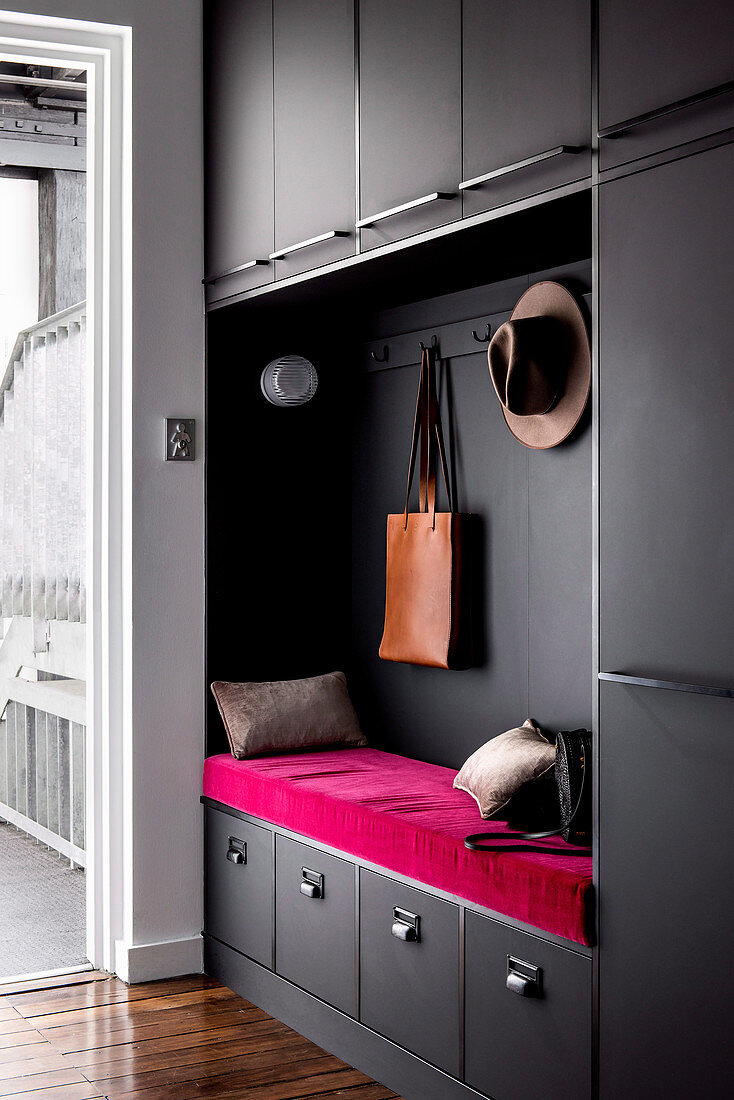 Alcove with pink bench in the black built-in cupboard in the hallway