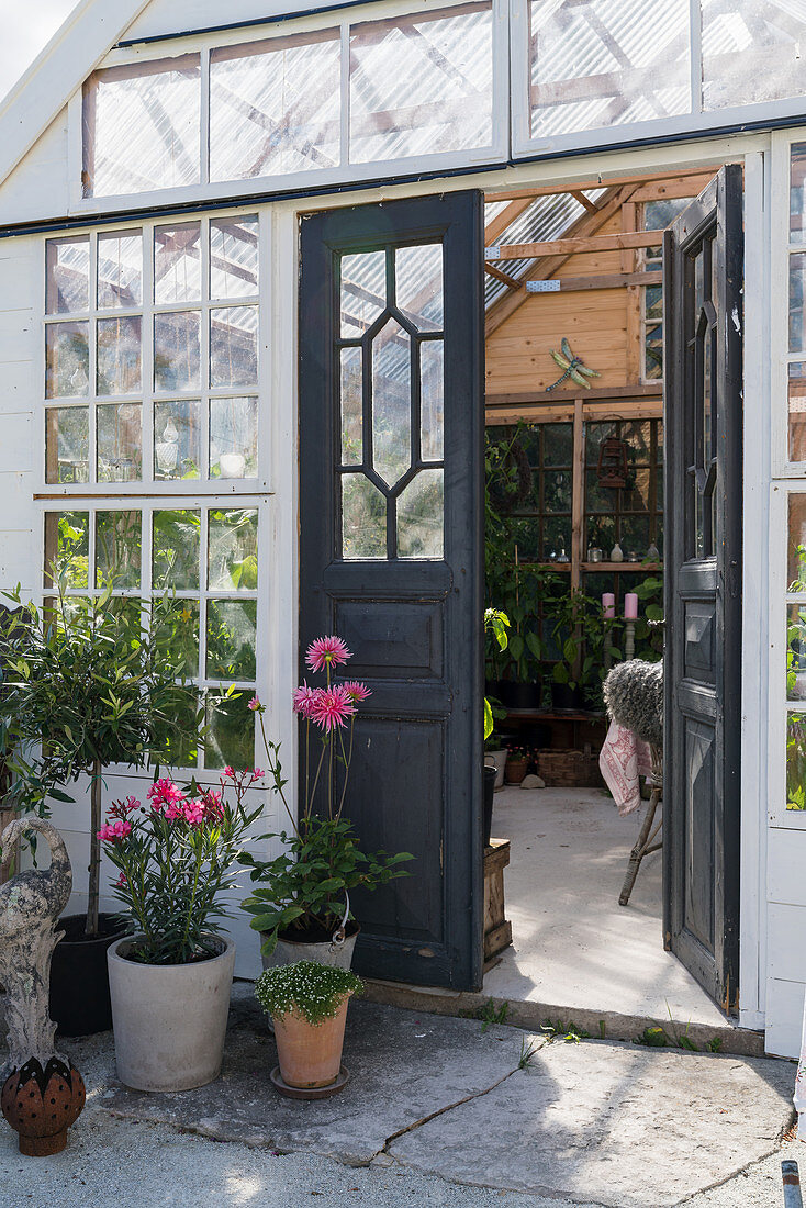 Offene Doppeltür zum romantischen Gartenhaus aus alten Fenstern
