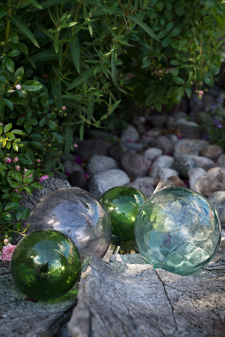 Glaskugeln als märchenhafte Dekoration auf Steinen im Garten