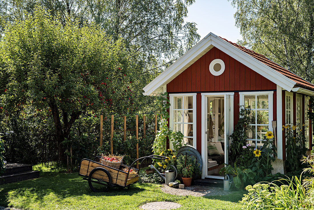 Rotes Gartenhaus im Skandinavischen Stil im Sommergarten