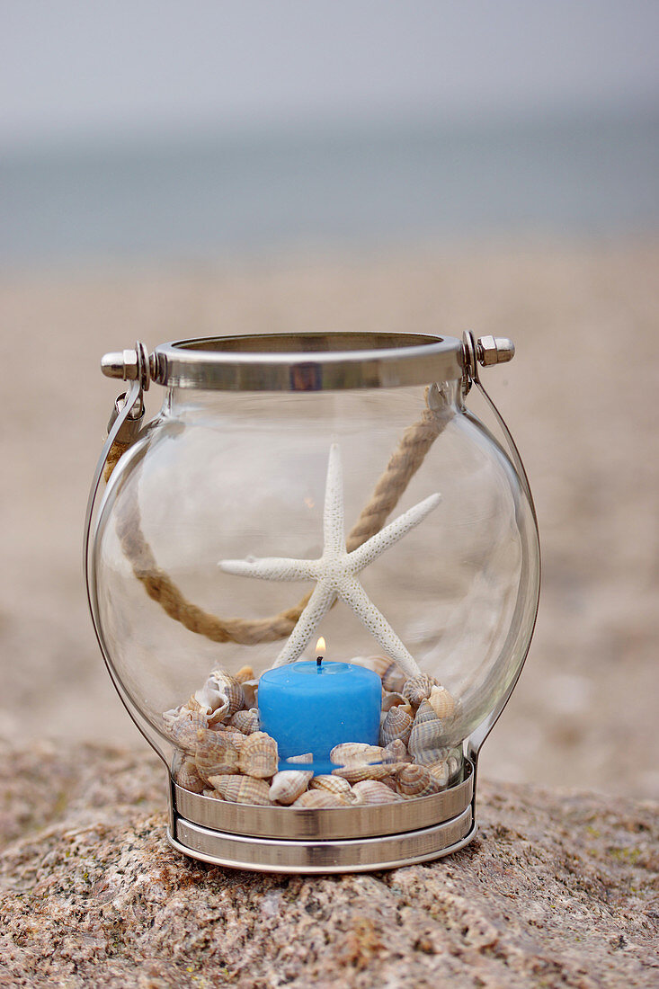 Candle lantern decorated with seashells and dried starfish