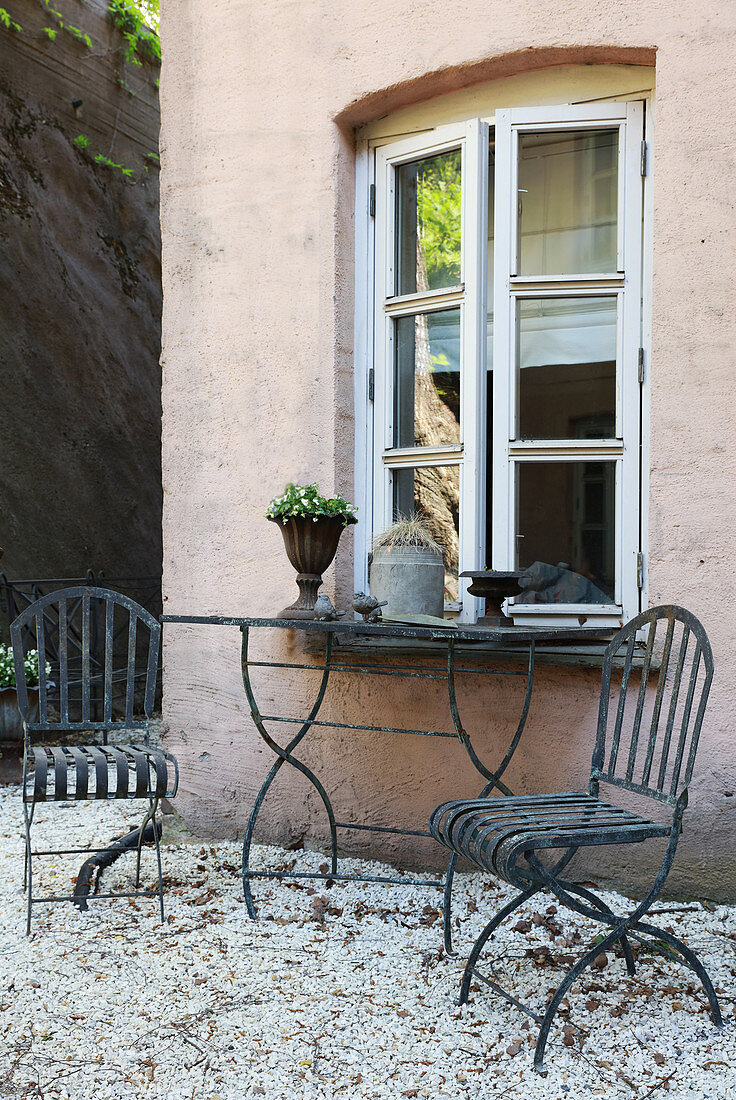 Mediterranean, metal garden furniture on gravel terrace outside house
