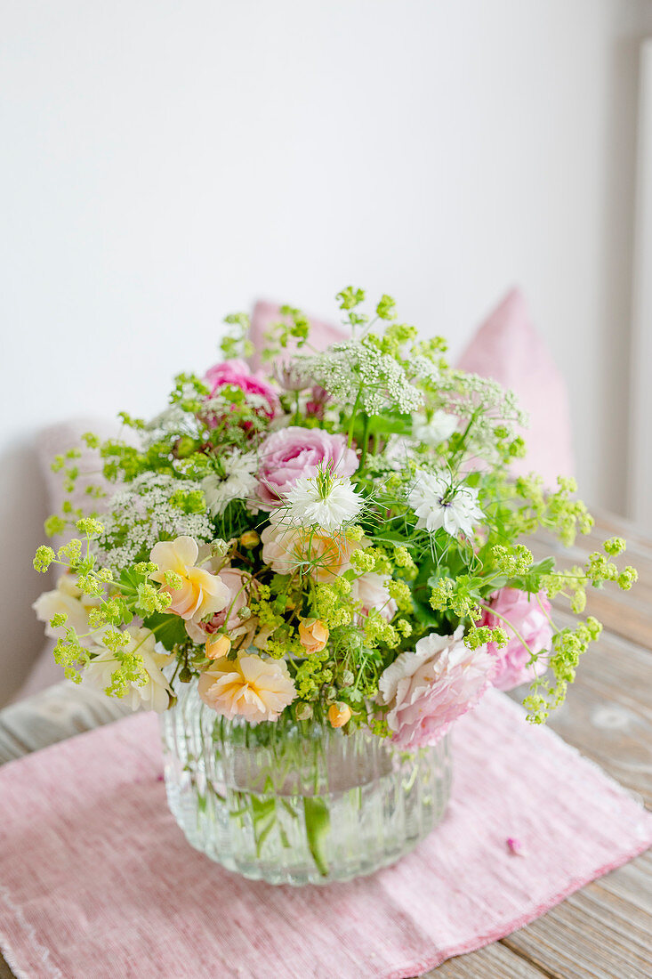 Summer bouquet with roses, lady's mantle and love-in-a-mist