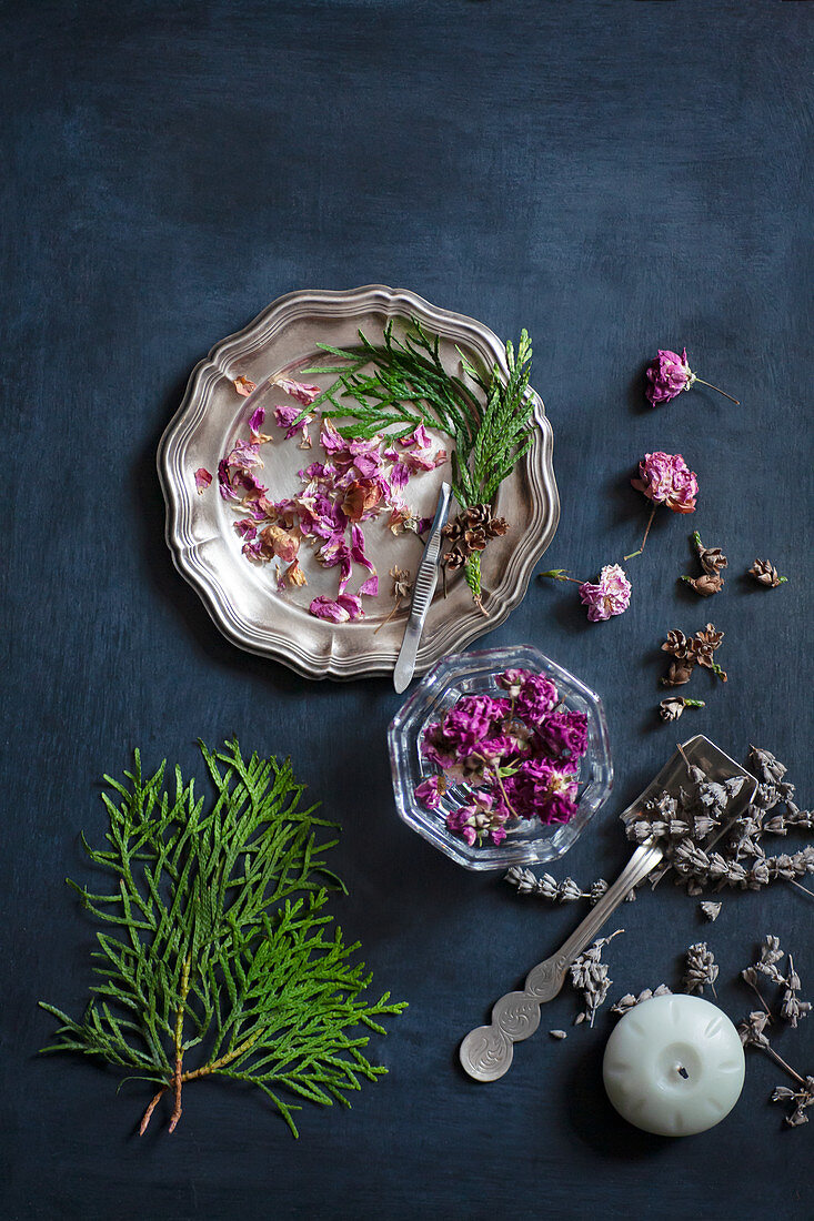 Getrocknete Blumen und Thujazweige auf alten Tellern