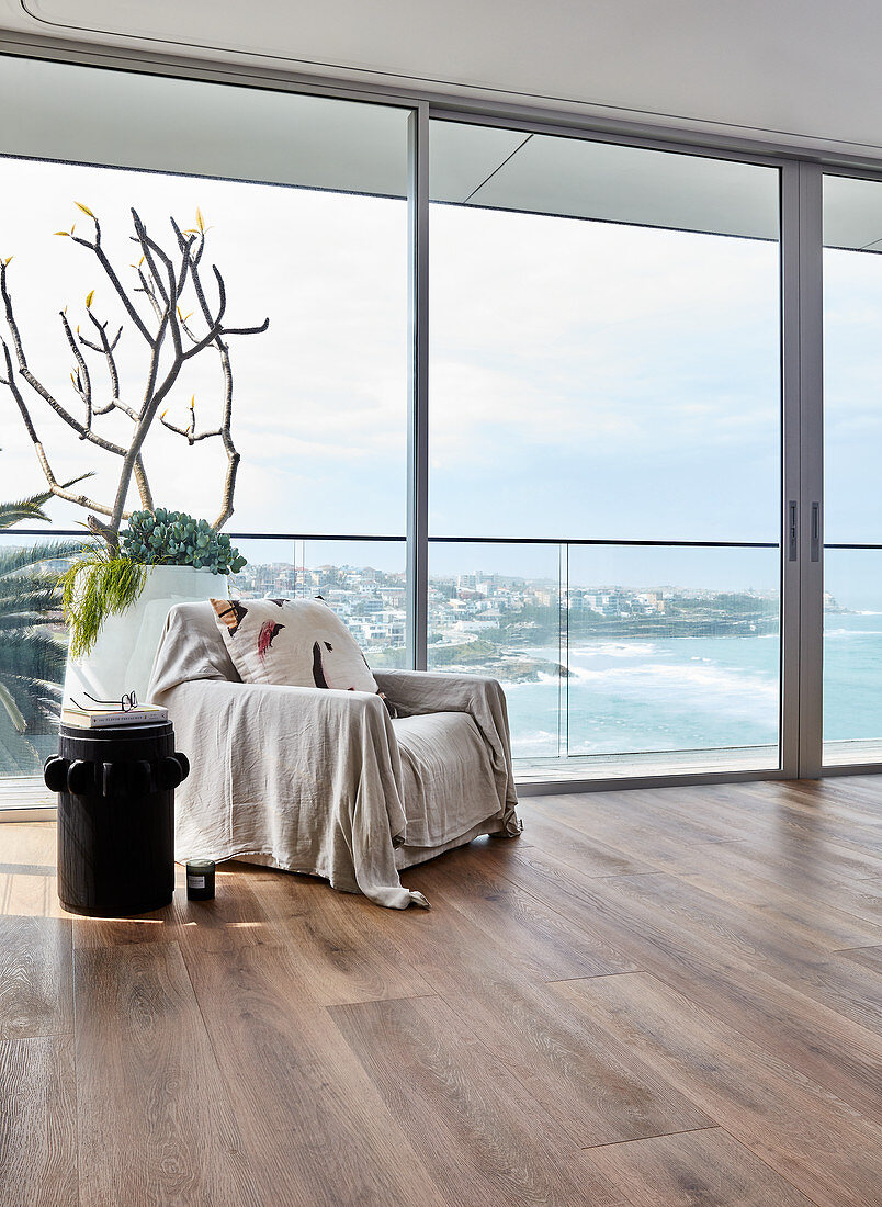 Throw on armchair next to glass wall with sea view