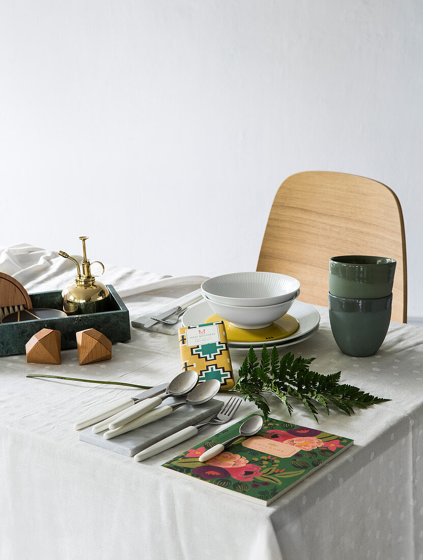 Gartenzubehör, Geschirr und Besteck auf dem Esstisch mit Tischdecke