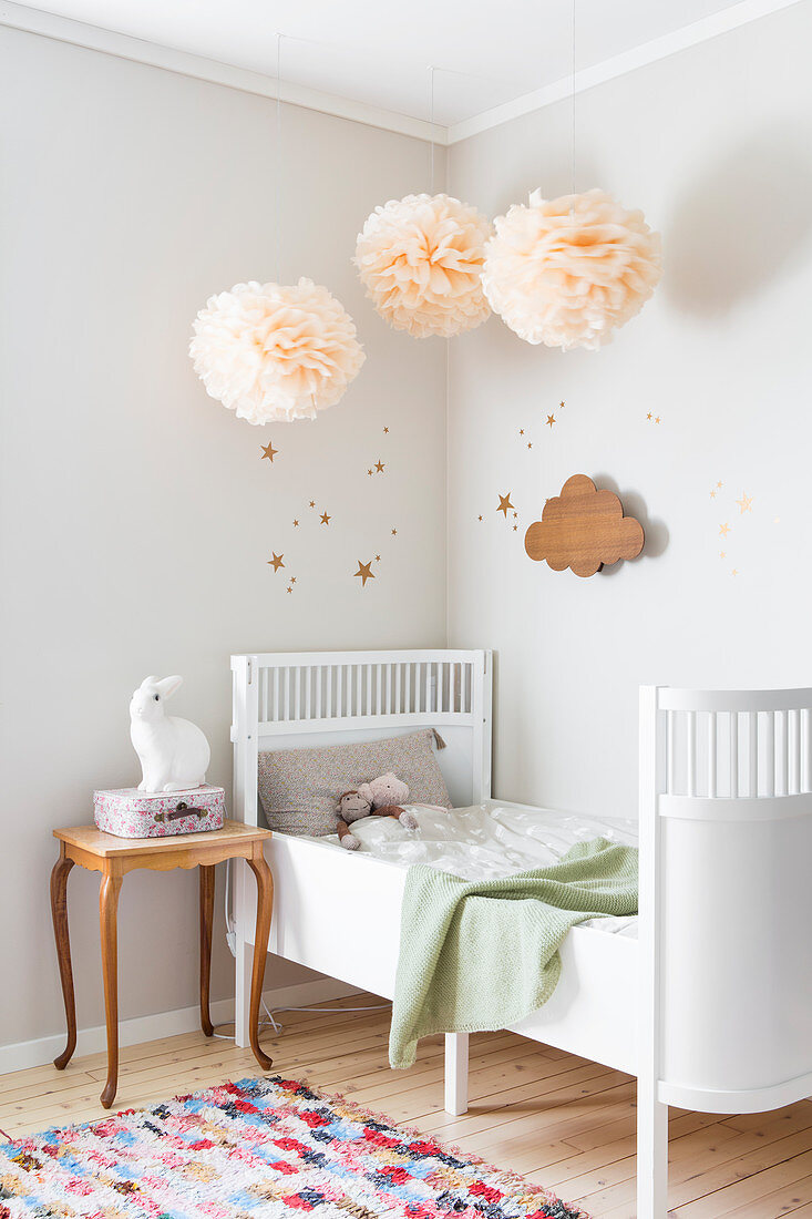 Pompoms above extendable child's bed in bedroom