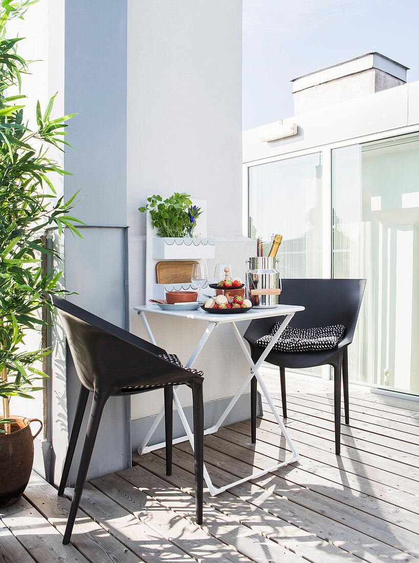 Plastic chairs at folding table on modern roof terrace