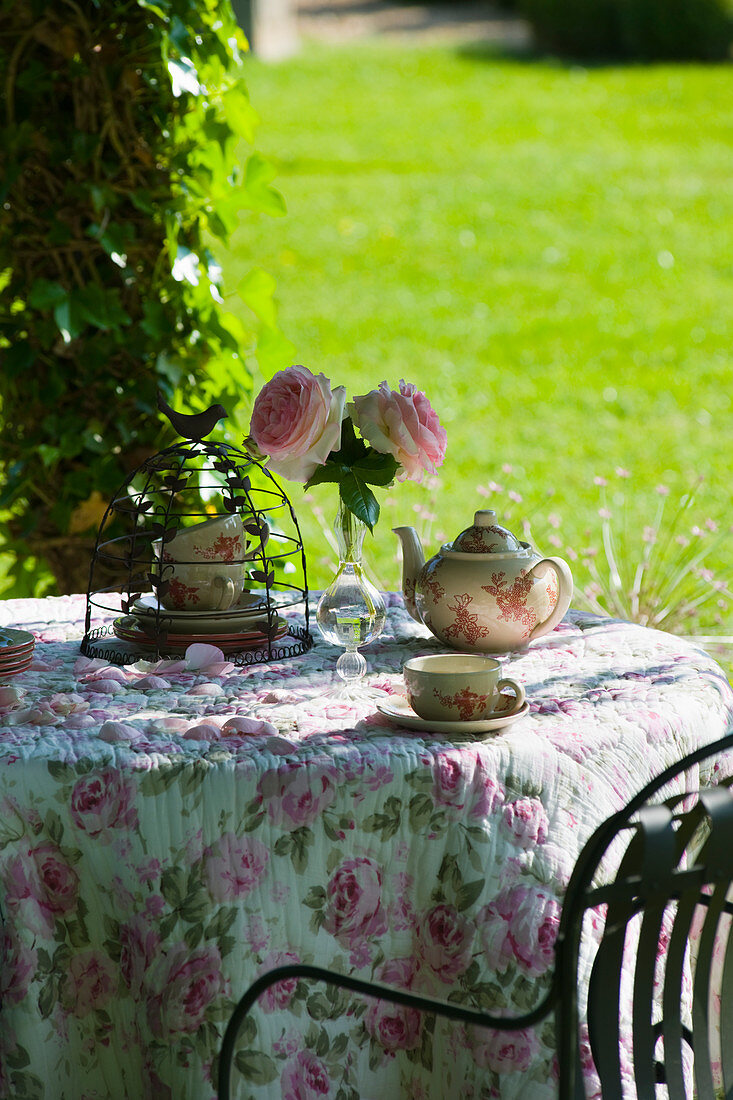 Romantisch gedeckter Kaffeetisch im sommerlichen Schloßgarten