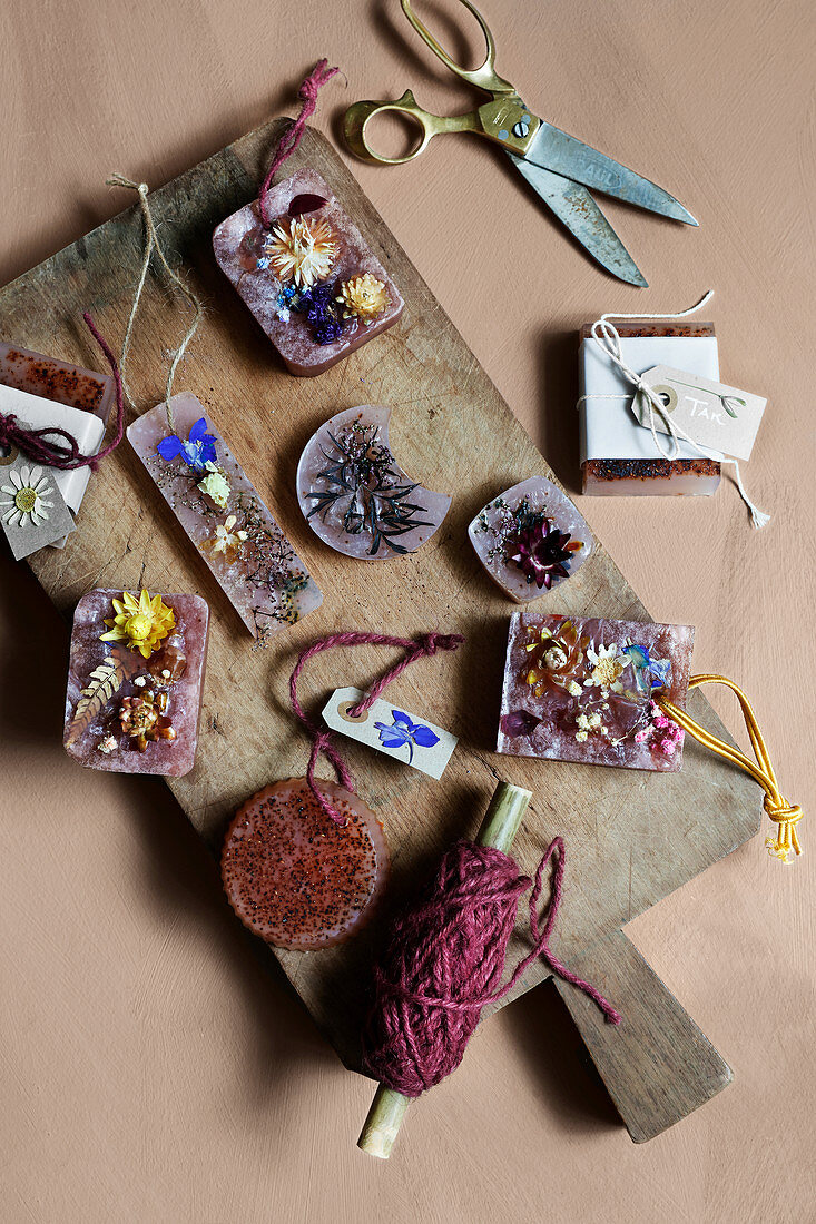 Handmade scented soap with dried flowers on wooden board