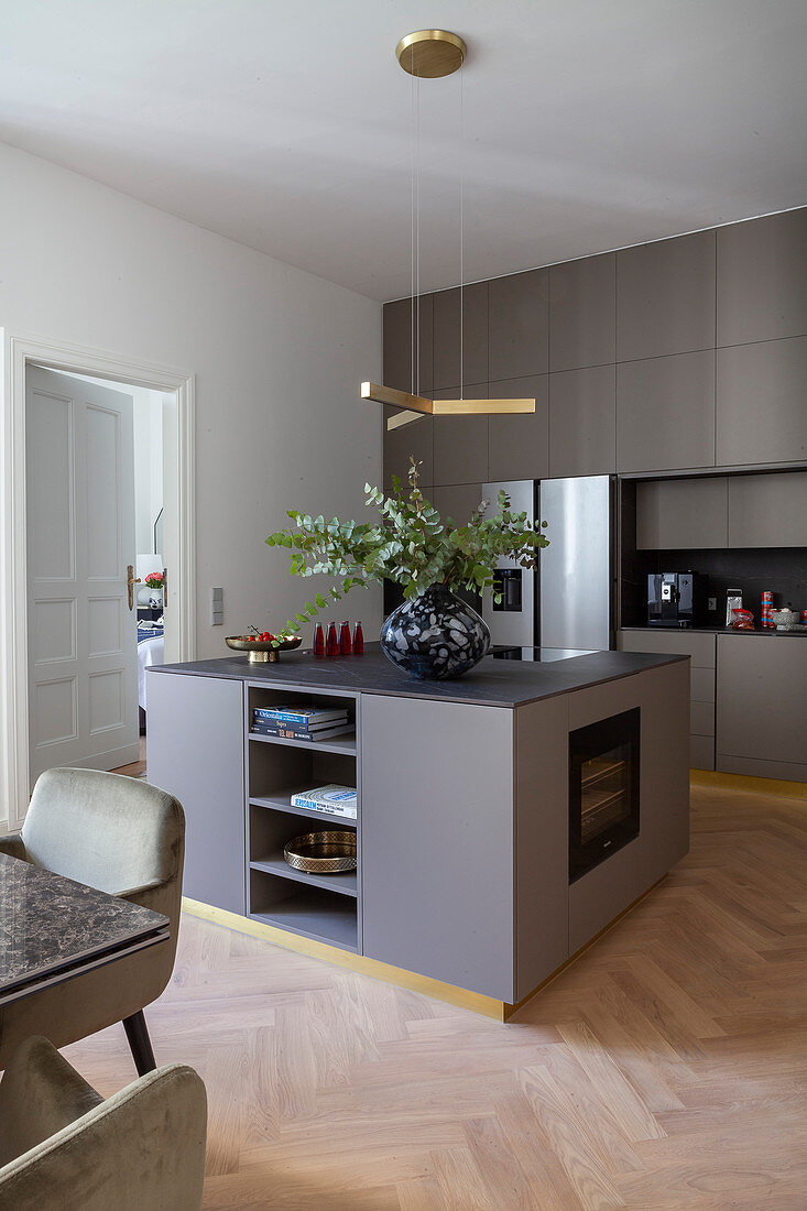 Moderne Küche in Grau mit Kücheninsel und goldenen Sockelleisten