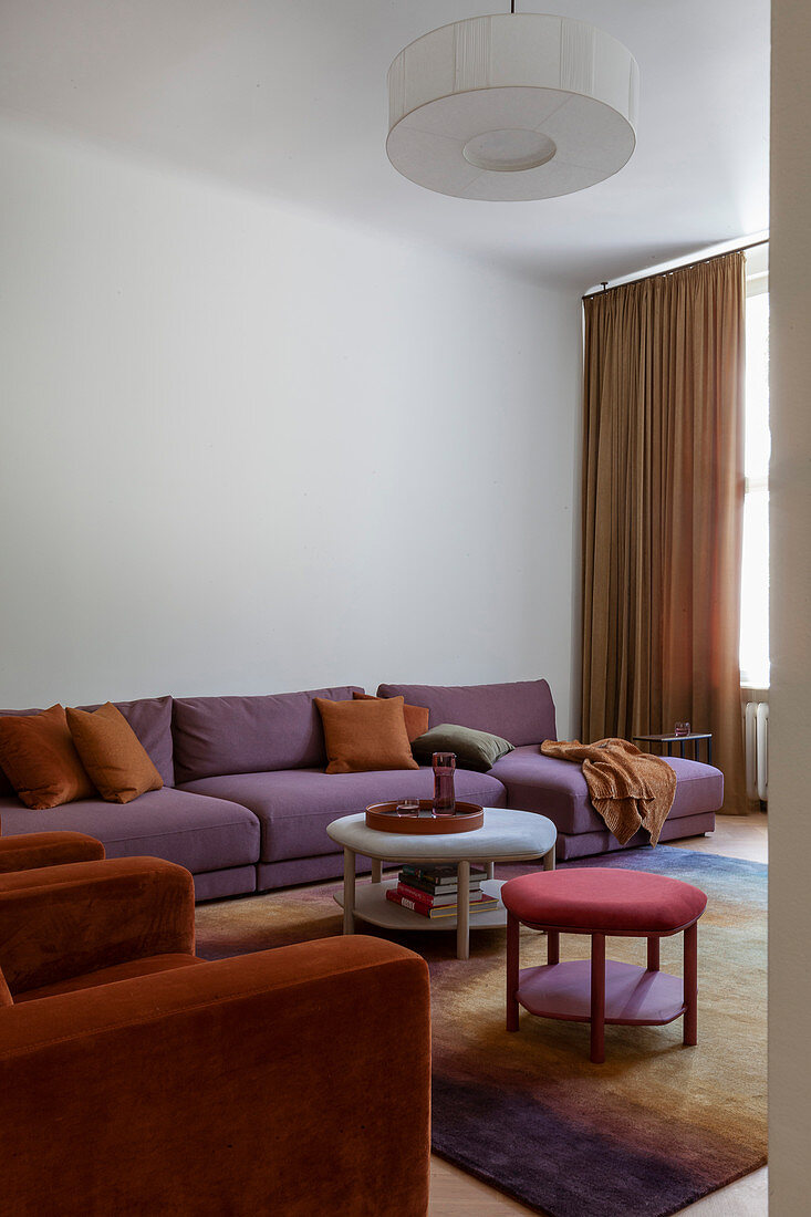 Orange armchairs and purple sofa in living room