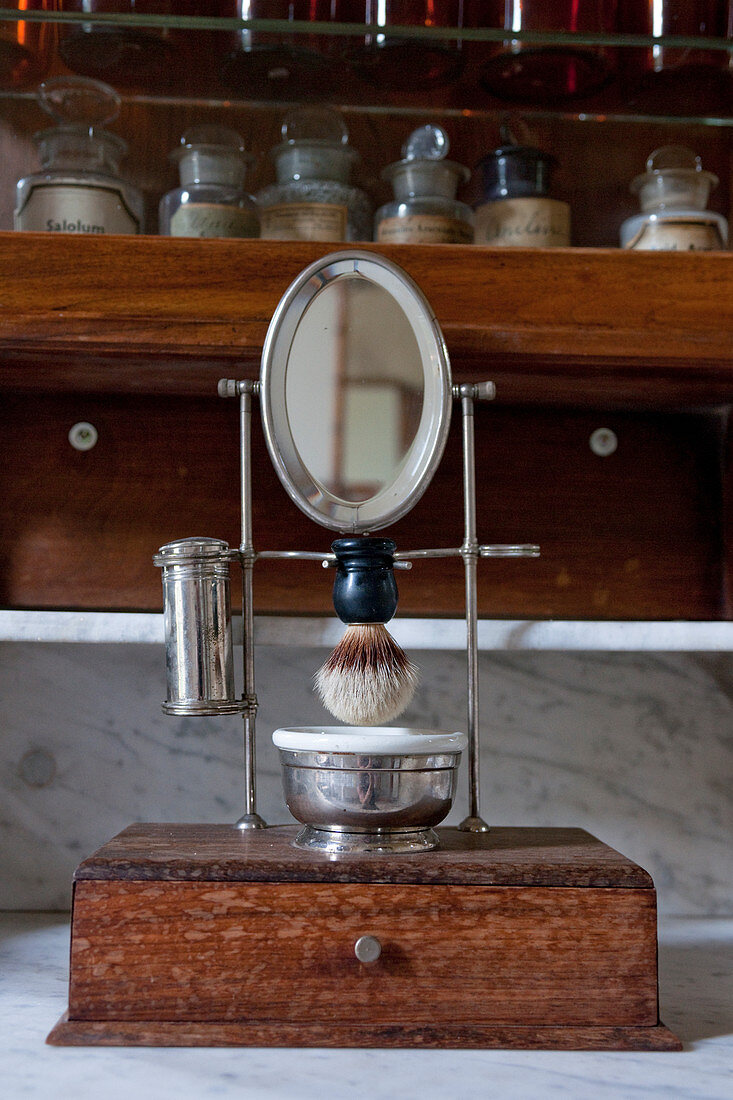 Mirror and shaving utensils on antique wooden stand