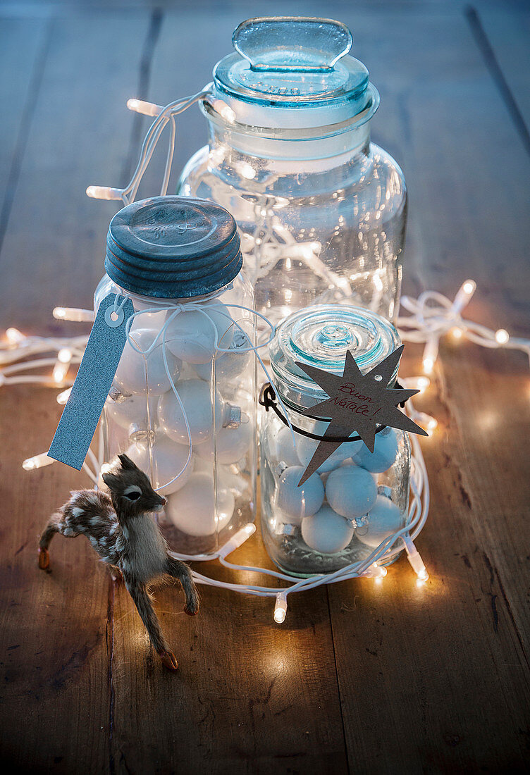Festive arrangement of fairy lights and preserving jars filled with baubles