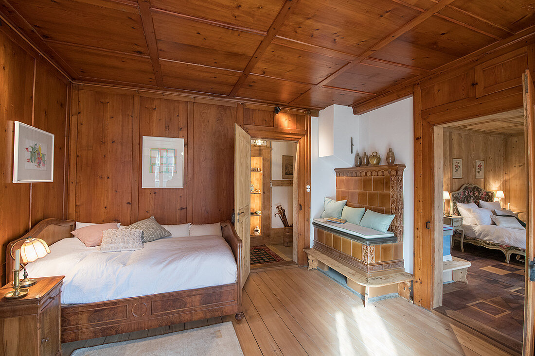 Traditionelles Schlafzimmer mit Holzvertäfelung und Kachelofen