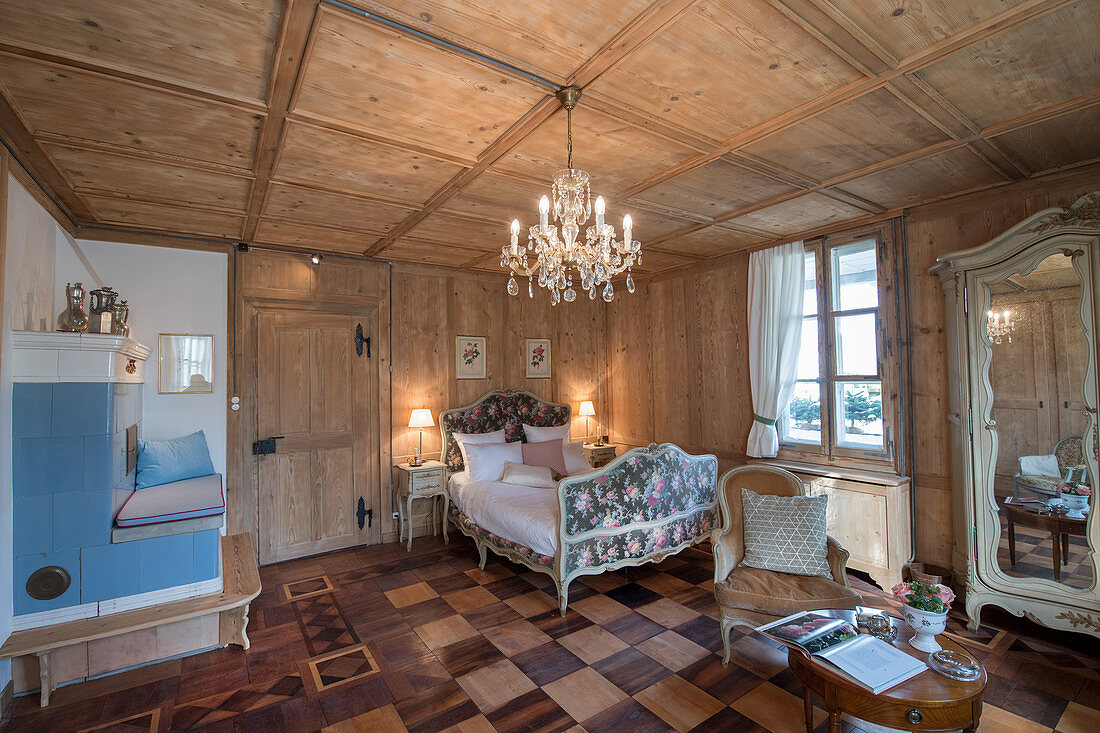 Traditionelles Schlafzimmer mit Holzvertäfelung und Kachelofen