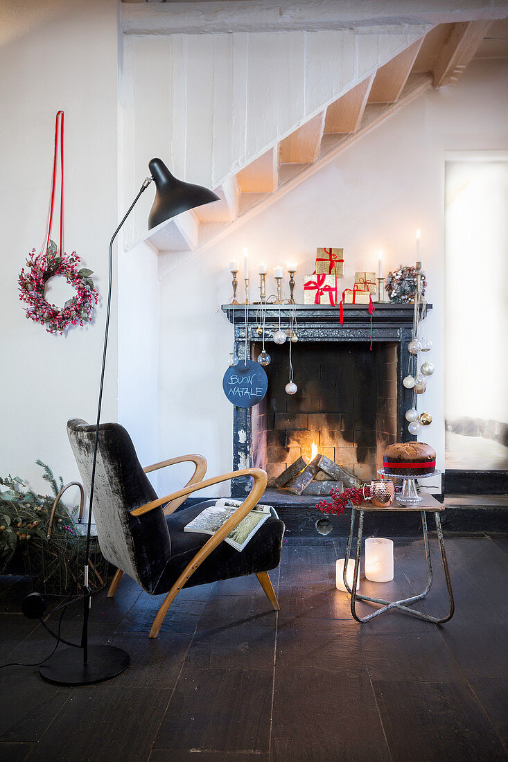Festively decorated interior with open fireplace below staircase