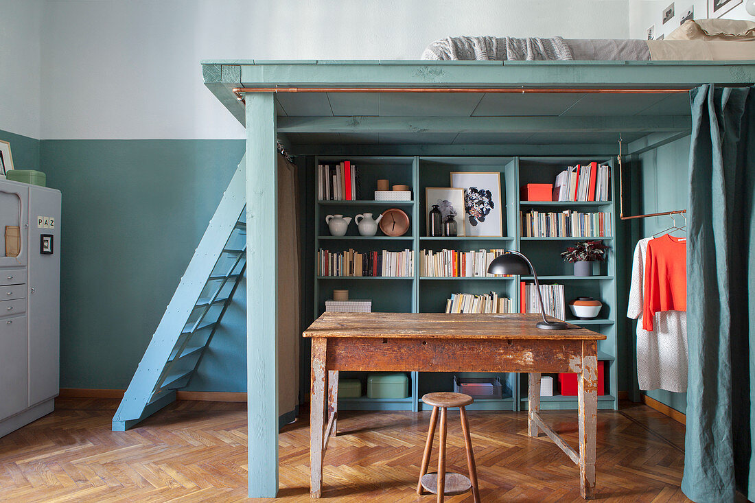 Schrankwand, Holztisch und Kleiderstange unter DIY-Hochbett