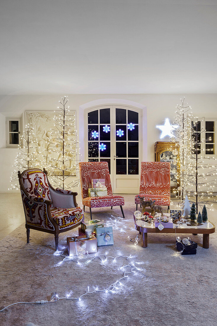 Living room festively decorated with fairy lights and stylised illuminated Christmas trees