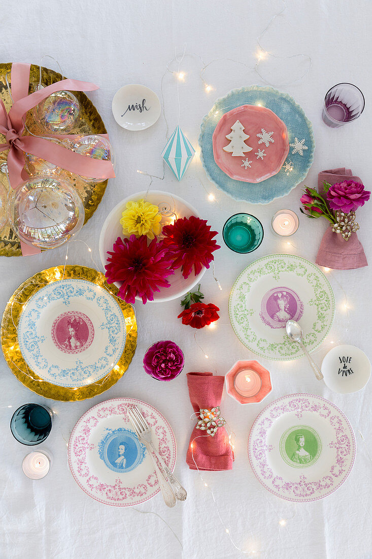 Dekorative Porzellanteller, Blumen und Windlichter als Weihnachtsdekoration