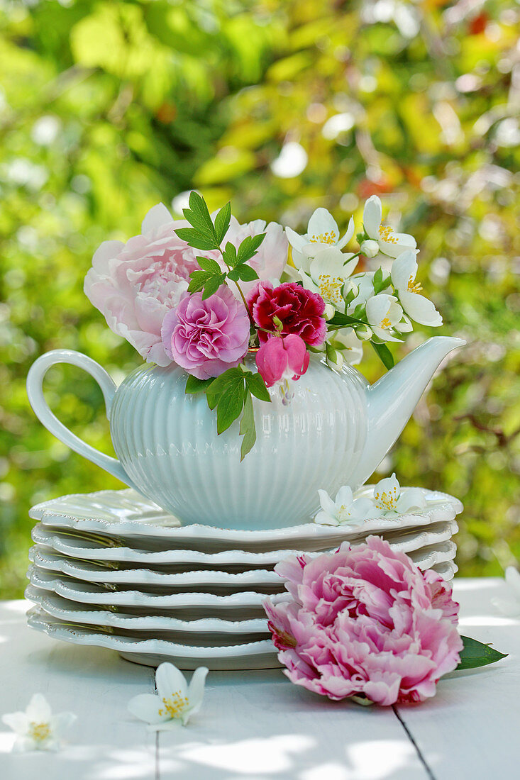 Early summer bouquet with peonies, carnations and English Dogwood in teapot