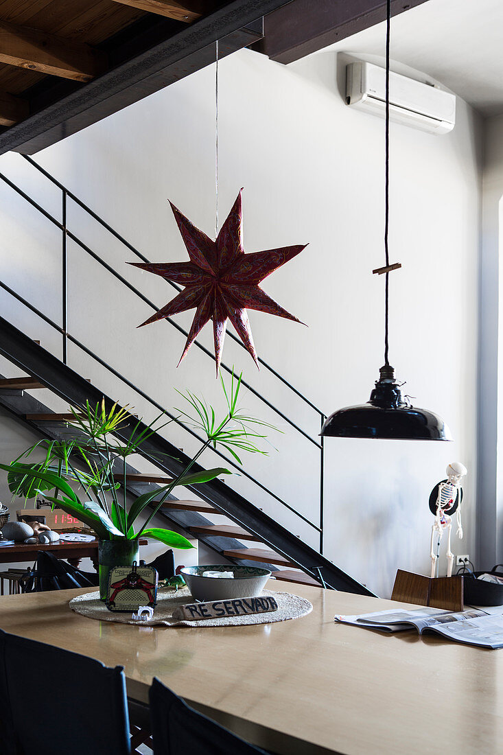 Pendant lamp and star decoration above pale dining table
