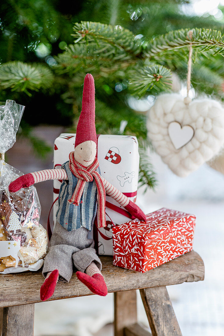 Wchtel und verpackte Geschenke auf dem Hocker vorm Weihnachtsbaum
