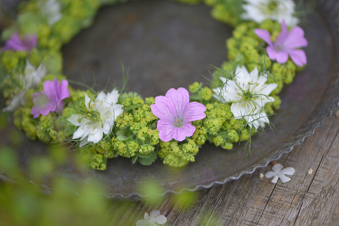 Summer wreath of lady's mantle, cranesbill and maiden in the green