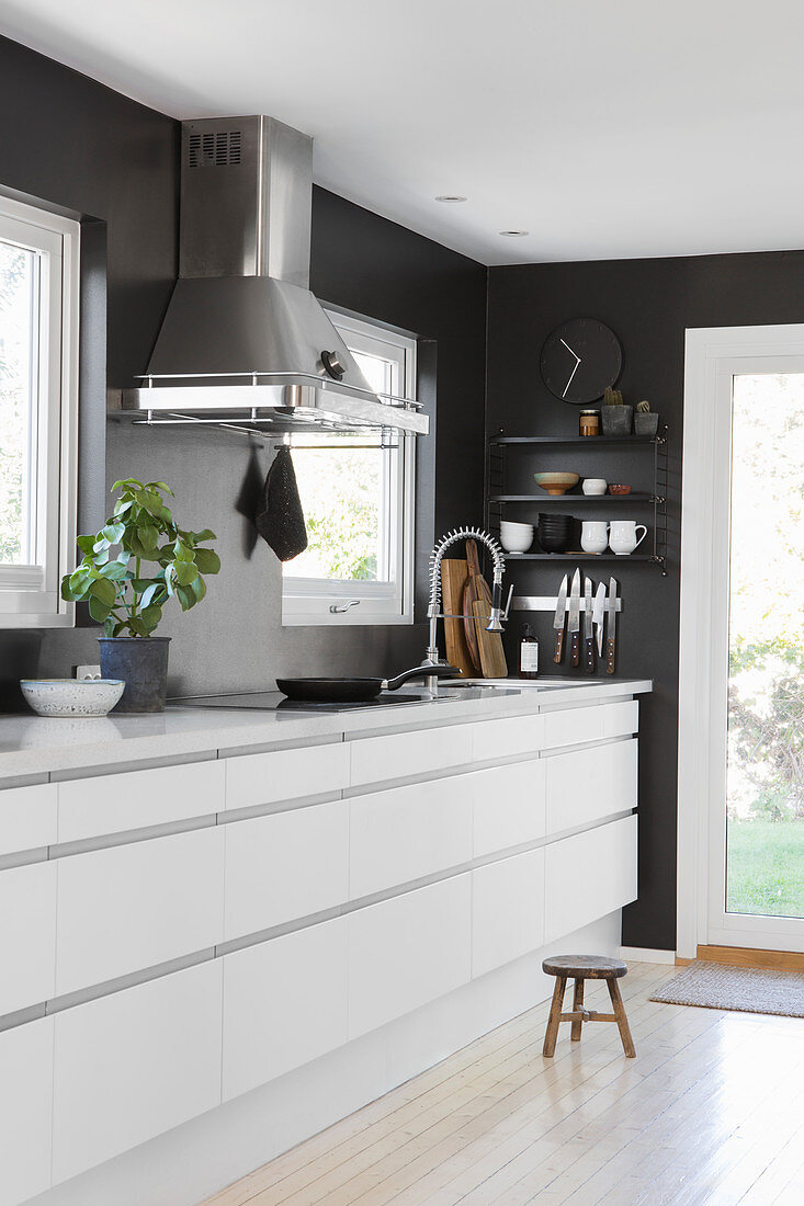 White, modern kitchen counter against black wall