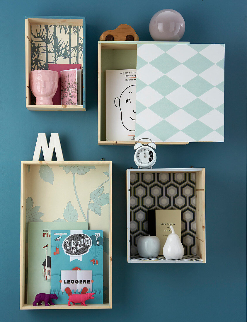 Shallow shelving modules covered in wallpaper with various patterns on wall