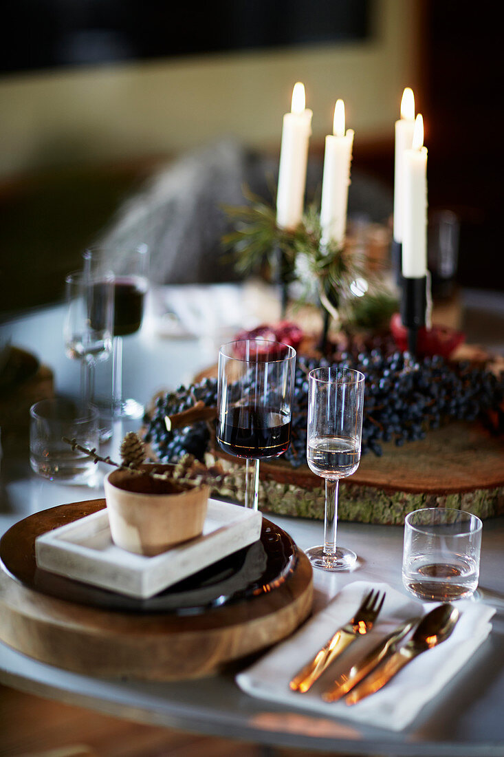 Festliches Gedeck auf Weihnachtstisch mit vier Kerzen