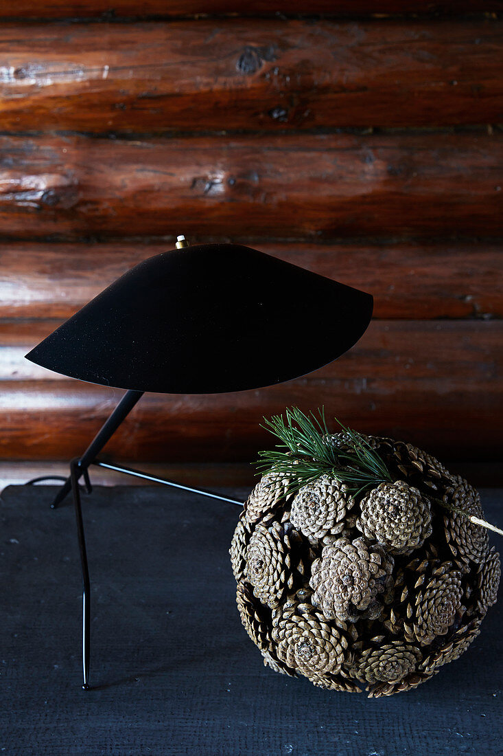 Ball of pine cones below black table lamp