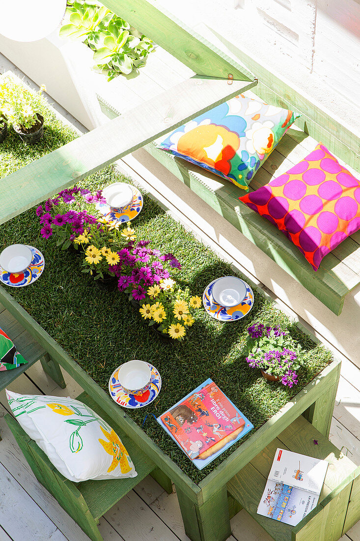 Tisch mit Rollrasen und Blumen auf der Terrasse