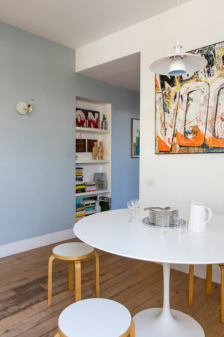 Abstract picture on wall above Tulip table and stacking stools in dining area