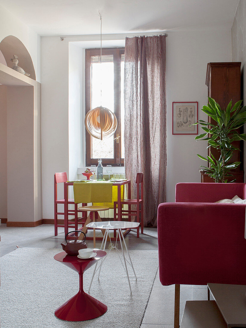 Rote Möbel im multifunktionalen Wohnzimmer mit weißem Boden