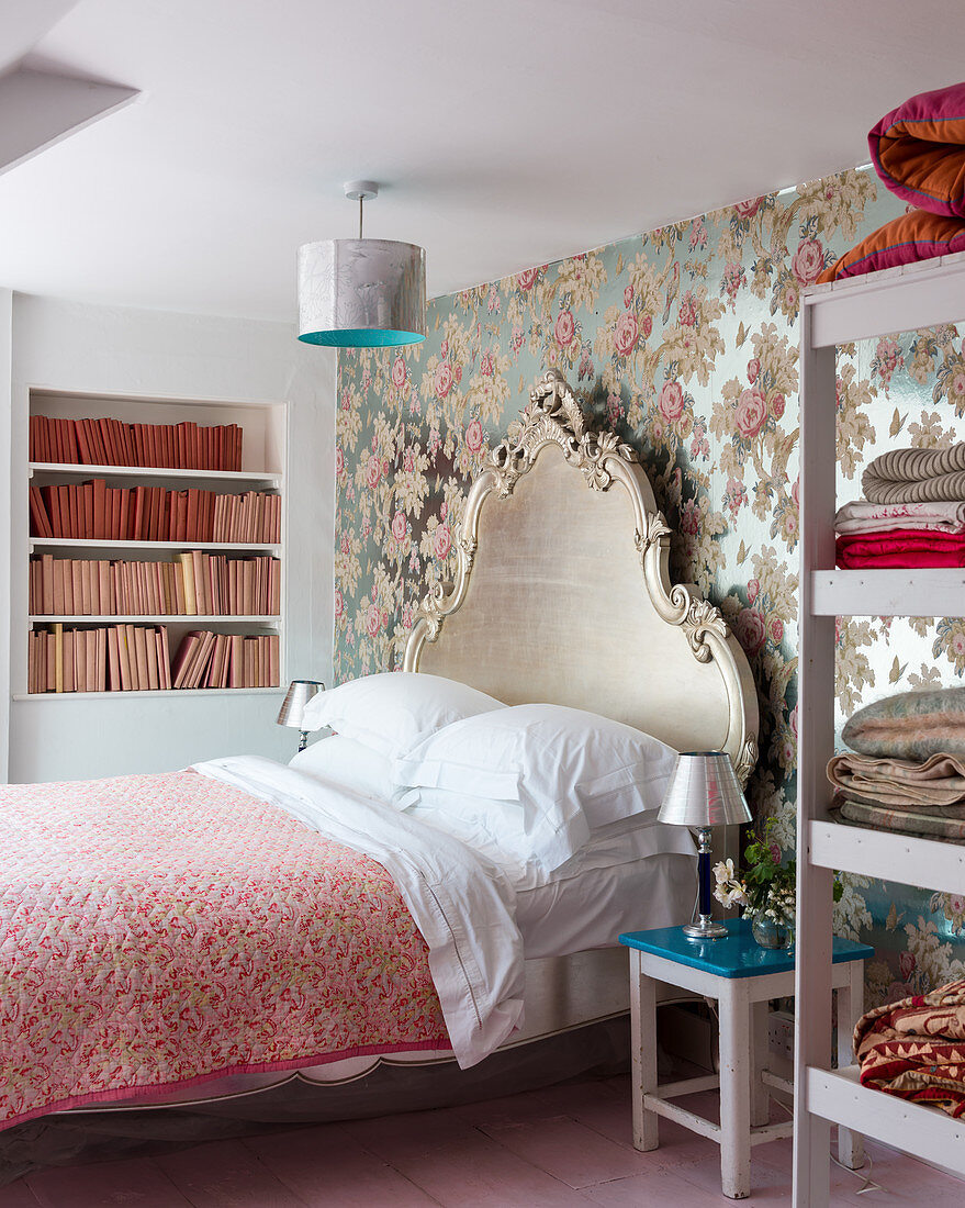 Bett mit Barockem Betthaupt vor glänzender Tapete mit Blumenmotiv