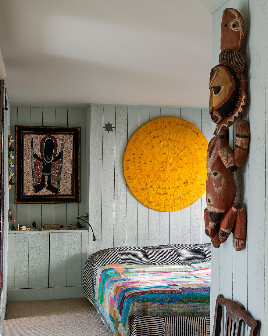 Ethnische Skulptur im Schlafzimmer mit hellblauer Bretterverkleidung