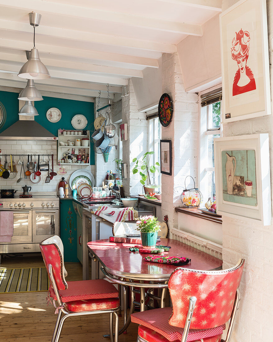 Rote Essgruppe im 50er-Jahre-Stil in offener Küche mit blauer Wand