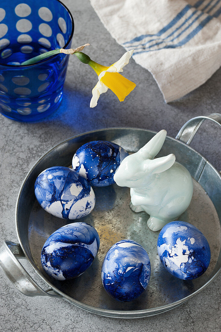 Blau marmorierte Ostereier und Osterhasenfigur
