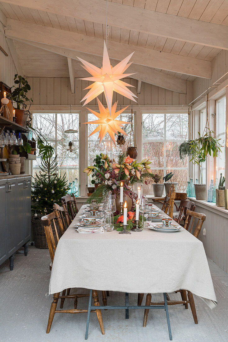 Festlich gedeckter Tisch im weihnachtlich dekorierten Wintergarten
