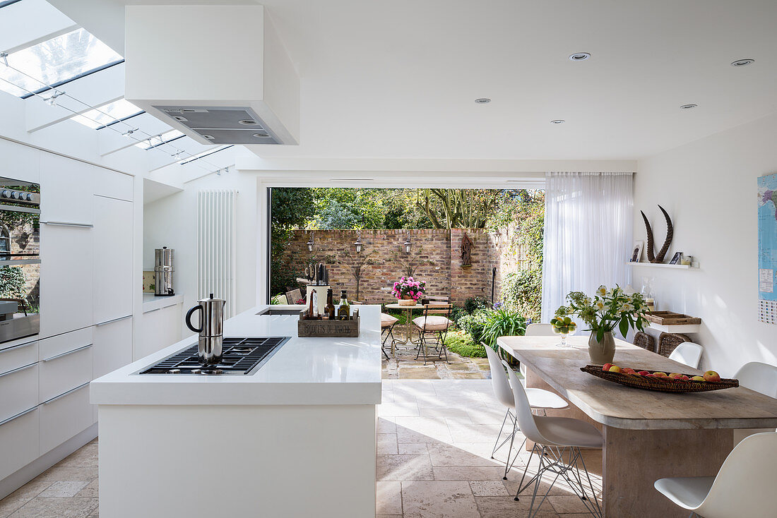 Moderner Wohnraum in Weiß mit offener Küche und Gartenzugang