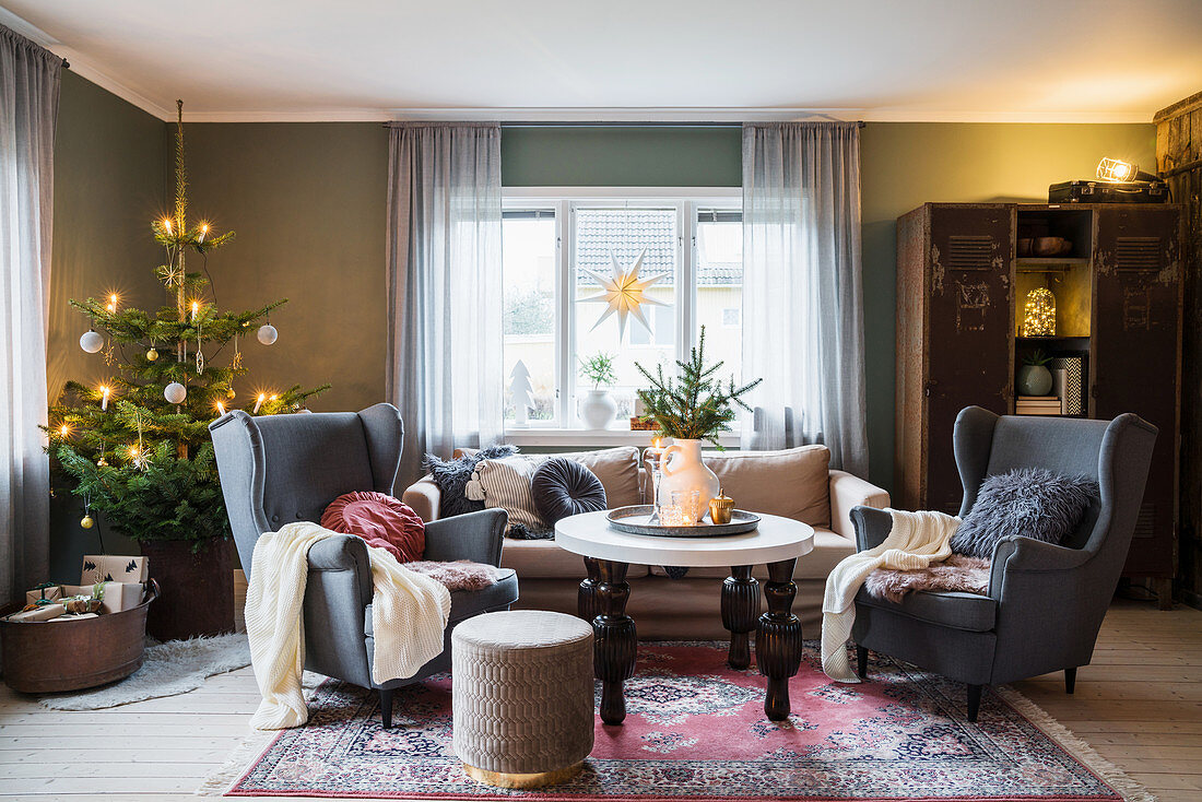 Gemütliches Wohnzimmer mit Ohrensesseln und Weihnachtsbaum