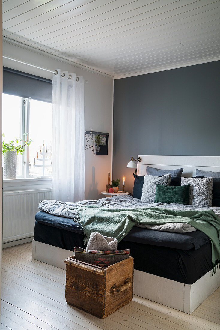 Doppelbett vor grauer Wand im Schlafzimmer