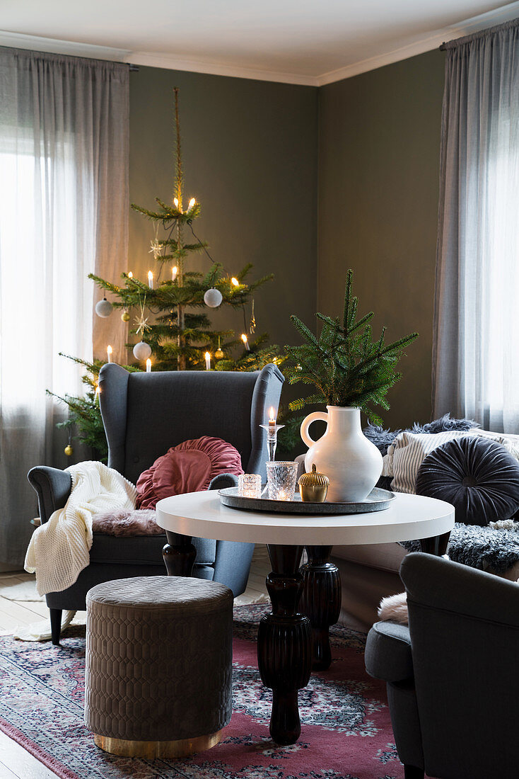 Gemütliches Wohnzimmer mit Ohrensessel und Weihnachtsbaum