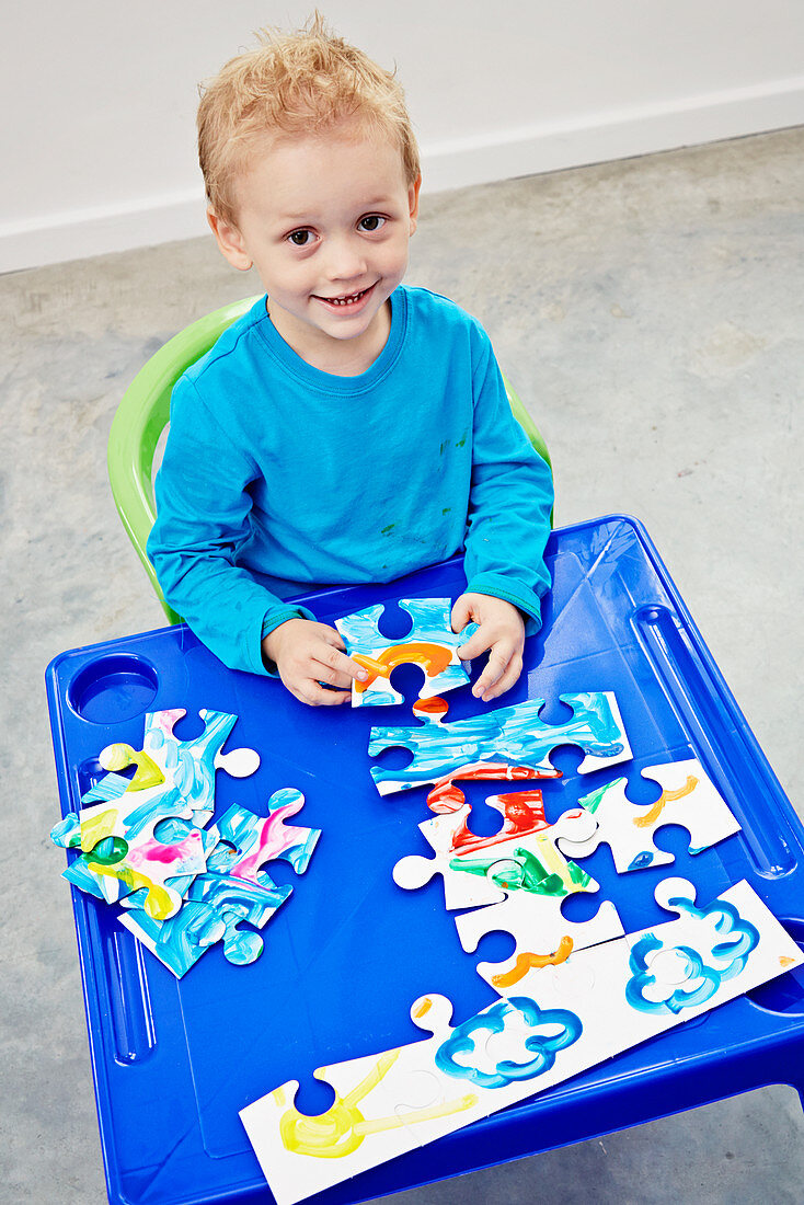 Little boy with hand-painted jigsaw