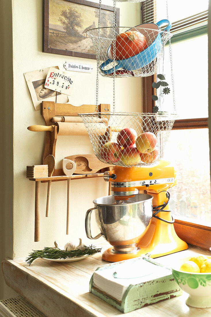 Mixer and hanging storage baskets in rustic kitchen