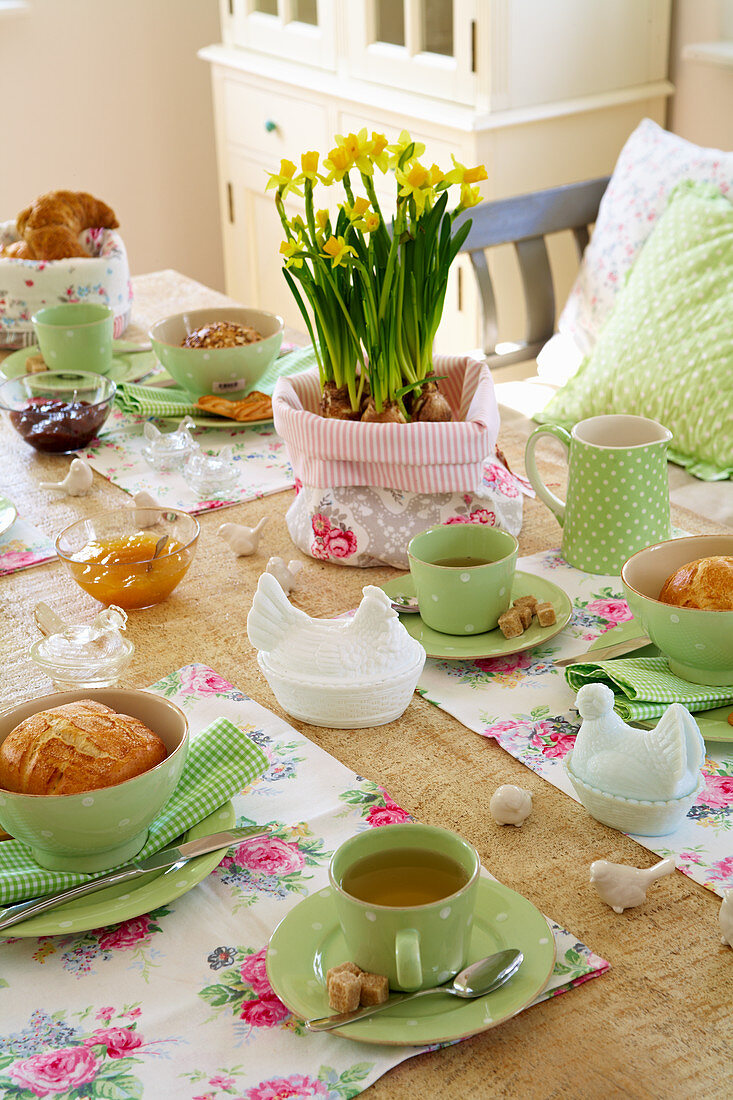Easter table prettily set with green crockery and floral placemats